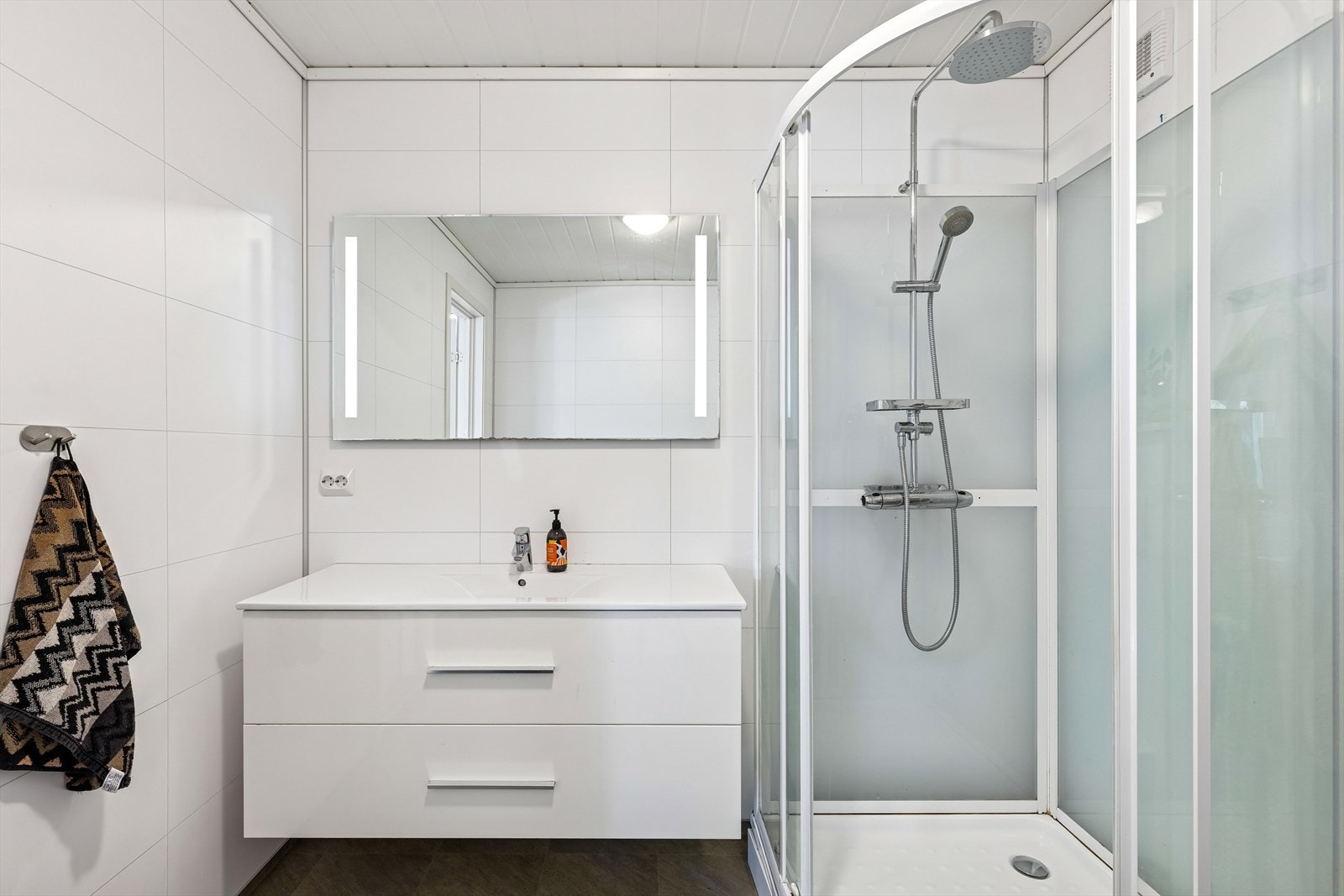 Bad i hovedetasje med våtromsplater på vegger og belegg på gulv. Galleribilde