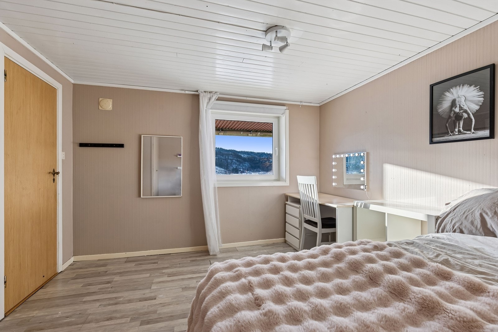 Soverom i kjeller med laminat gulv, panel i tak og tapet på vegger. Galleribilde