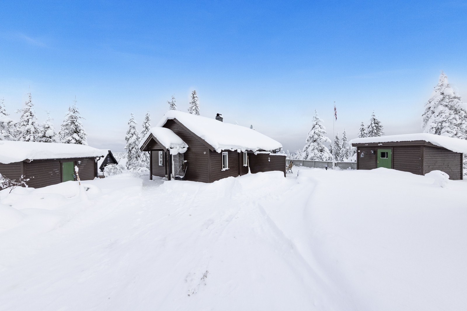 Enkel adkomst med kjørevei nesten helt frem til døra. Ved- og redskapsbod ses til venstre. Utebod for lagring til høyre Galleribilde