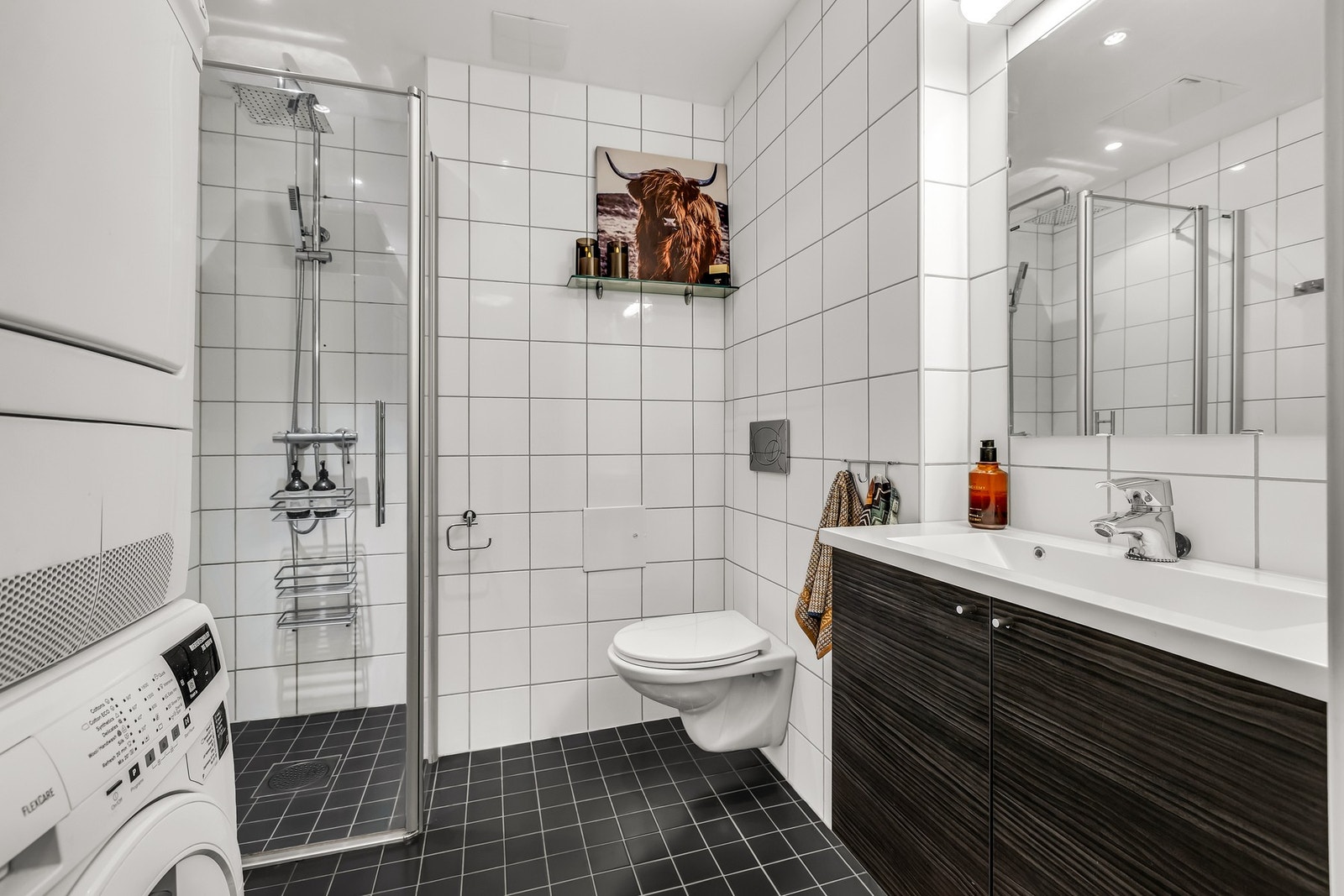 Innbydende bad, med mørke fliser på gulv, og lyse fliser på veggene Galleribilde