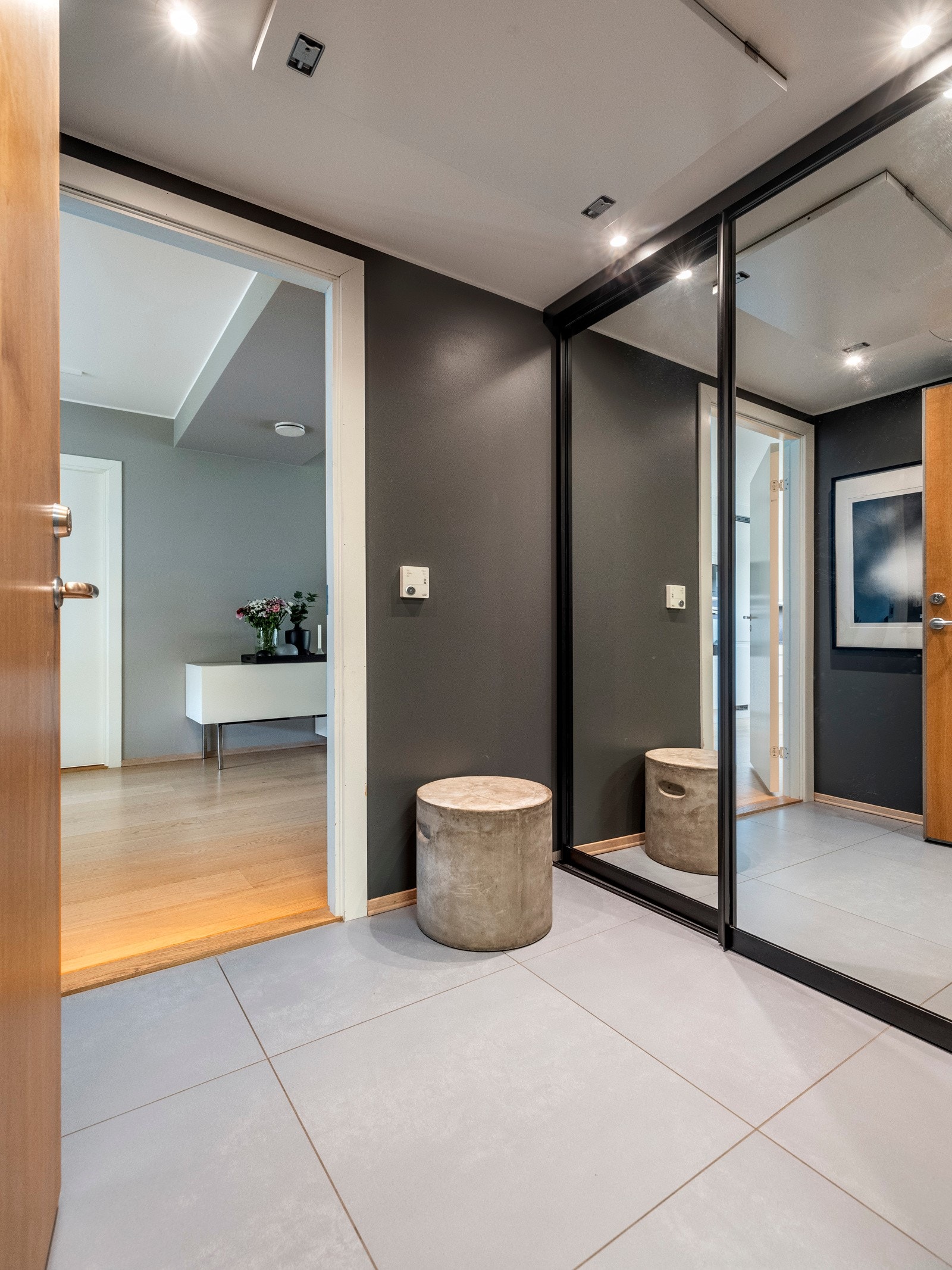 Entréen har malte vegger i mørke fargetoner og lysegrå fliser på gulvet utstyrt med vannbåren gulvvarme. Galleribilde