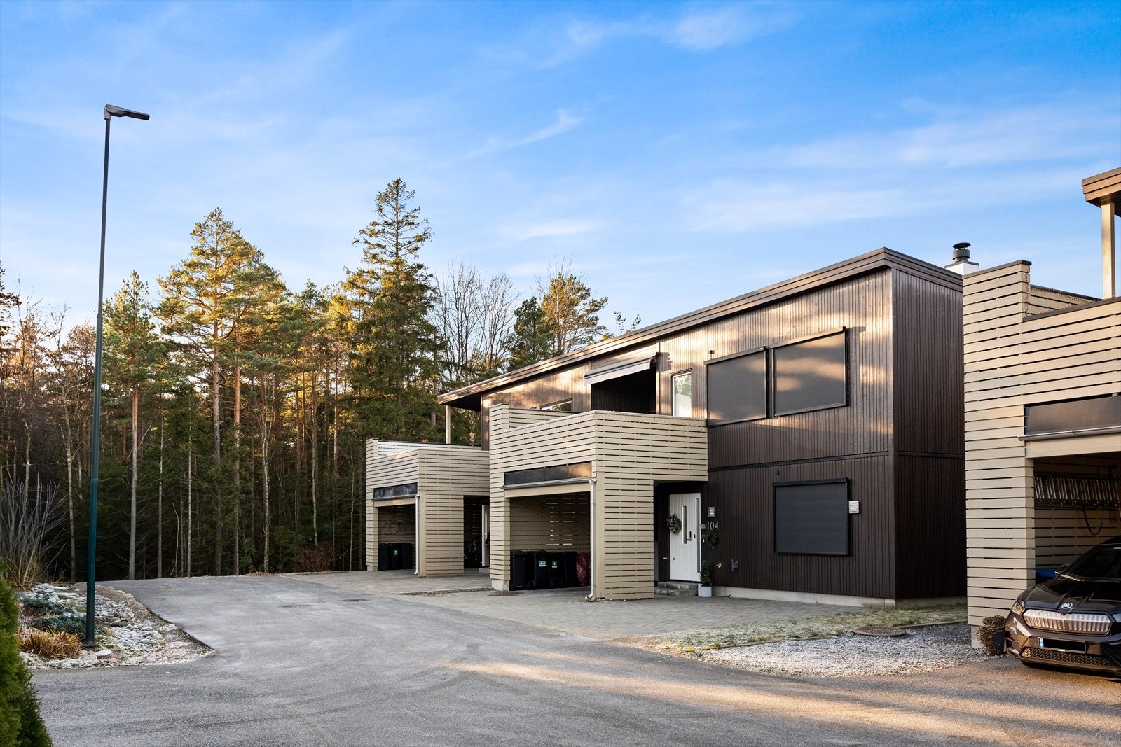 Boligen har en moderne fasade med stående kledning og trevinduer. Galleribilde