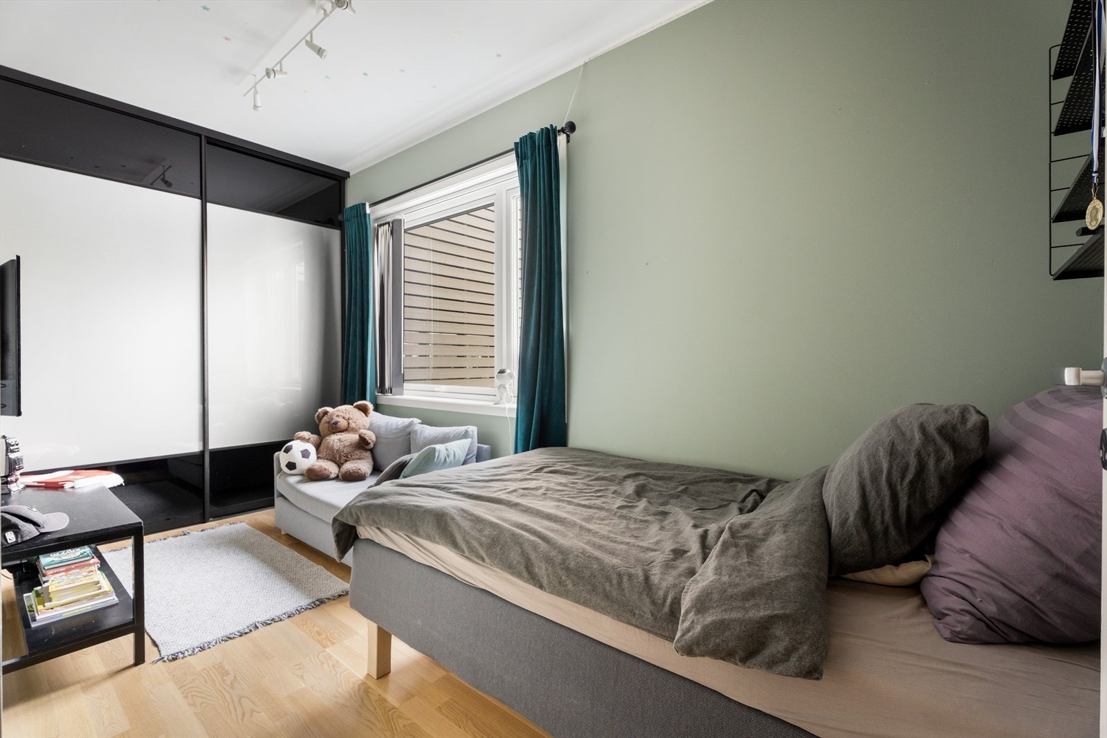 Skyvedørsgarderobe gir rommet en praktisk oppbevaringsløsning. Galleribilde