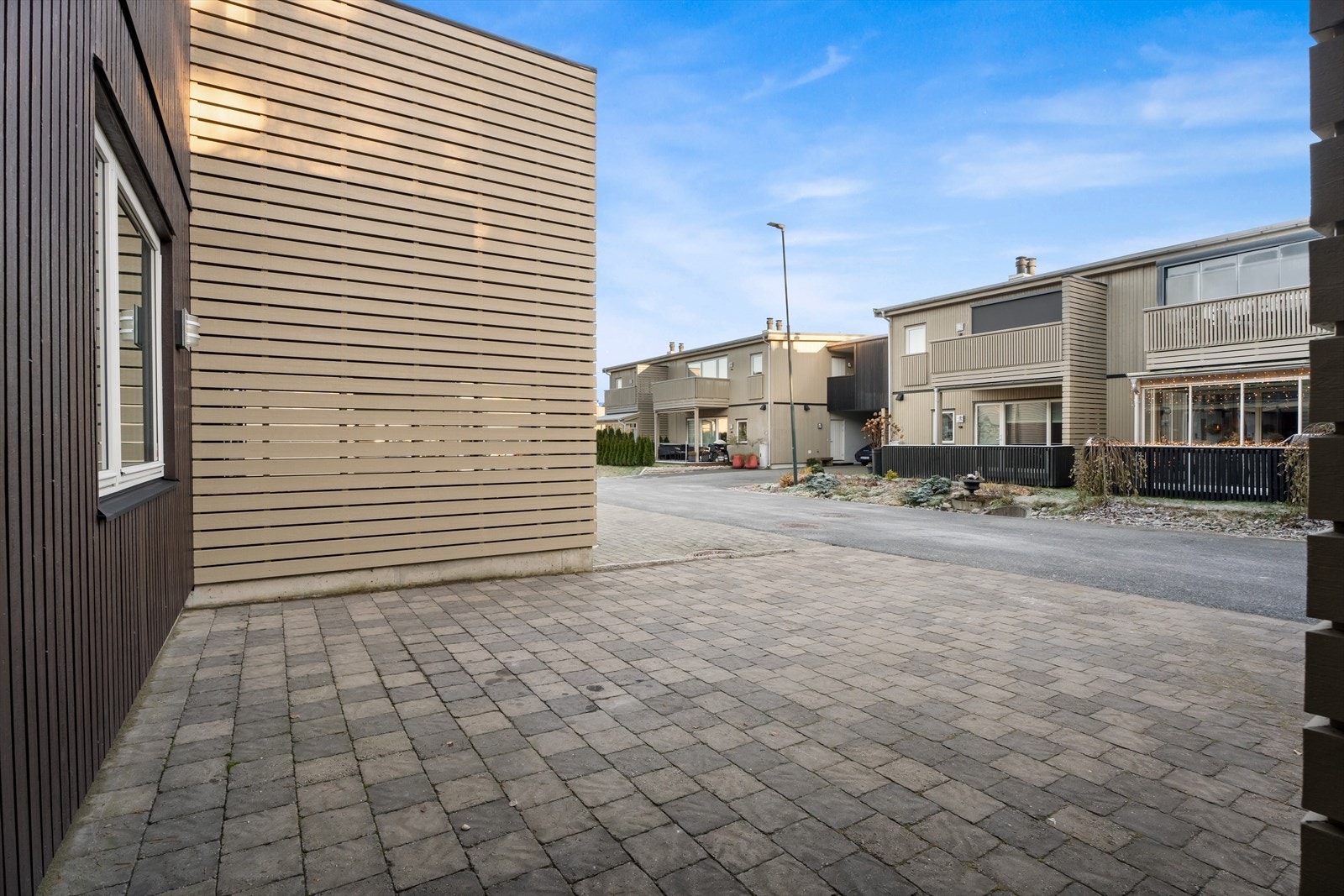 Steinlagt gårdsplass gir enkel adkomst til boligen via gaten. Galleribilde