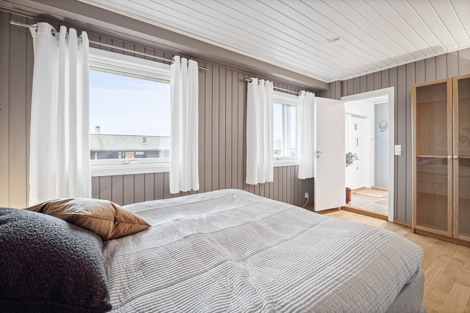 Soverom i underetasjen med 2-stavs parkett og panel på veggene. Galleribilde