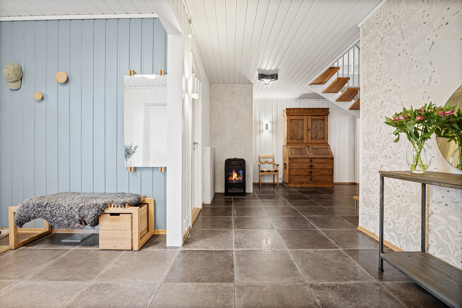 I underetasjen møtes du av en romslig gang med flislagt gulv og en Jøtul peisovn. Galleribilde