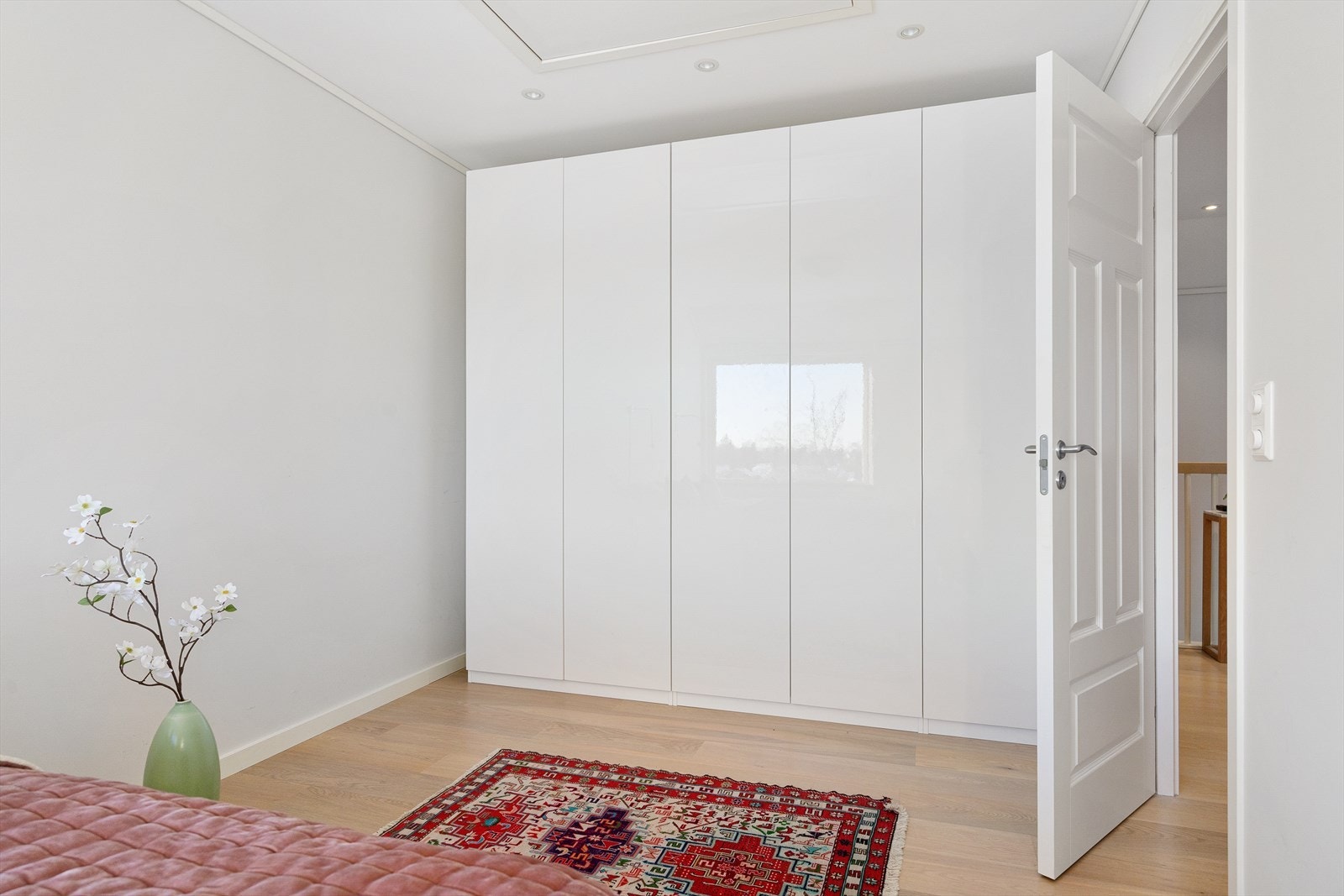 Romslig garderobeskap med glatte fronter følger med handelen. Galleribilde