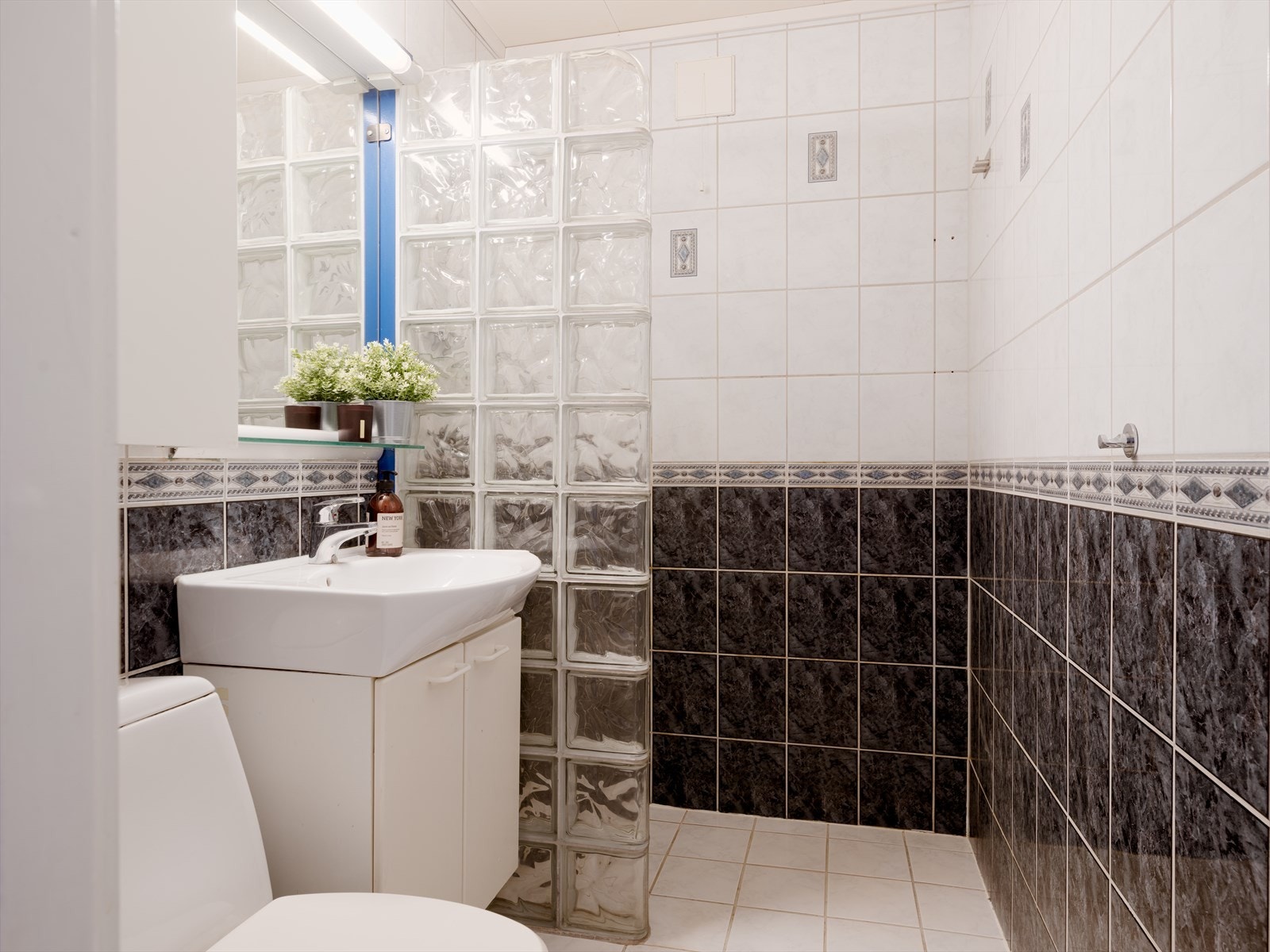 Baderommet er utstyrt med gulvmontert toalett og dusjhjørne med glassbyggerstein. Galleribilde