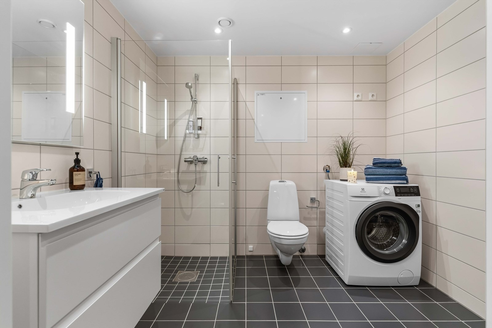 Flislagt bad med dusjhjørne og moderne innredning Galleribilde