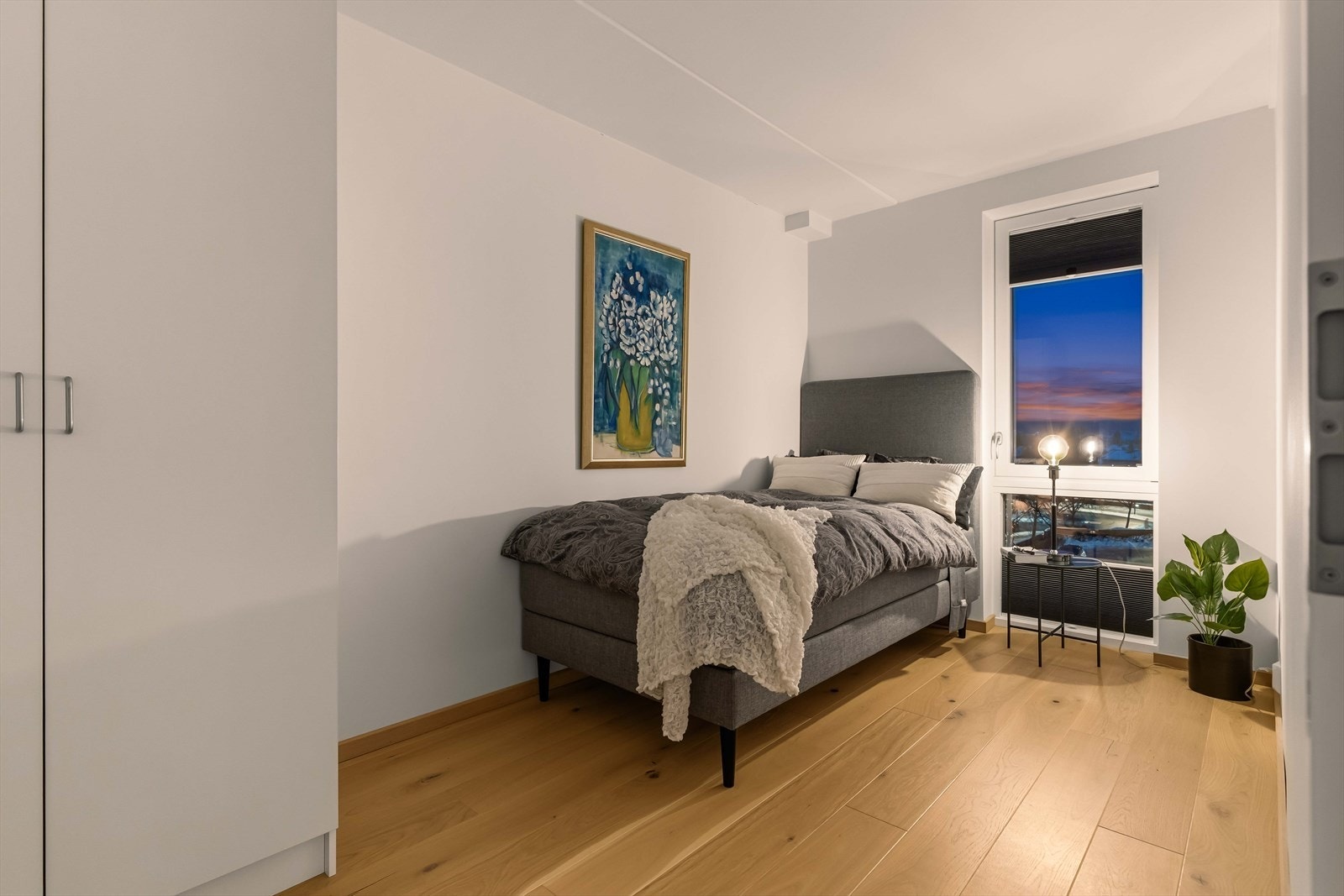 Lyst og innbydende soverom med parkett og malte flater Galleribilde