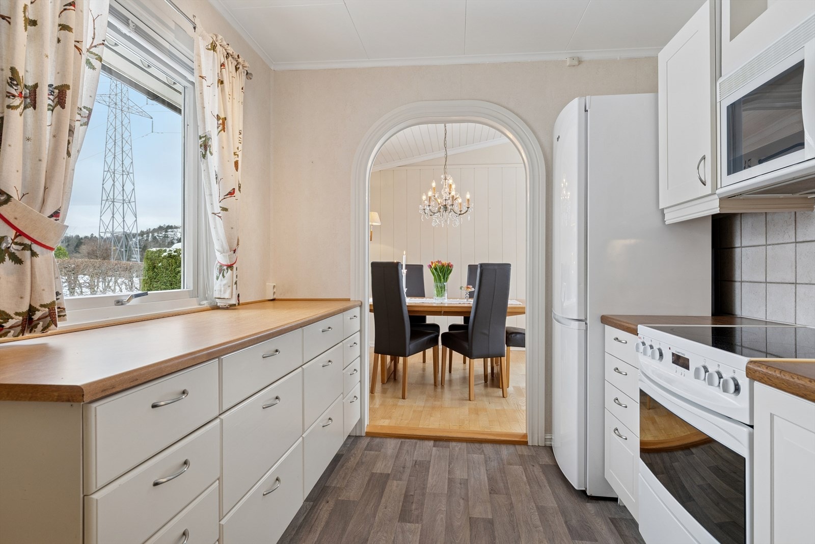 Godt med skap- og benkeplass gjør kjøkkenet funksjonelt og lett å arbeide i. Kjøkkenet er innredet slik at matlagingen forenes med sosialt samvær. Det generøse vinduet slipper inn mye naturlig lys. Galleribilde