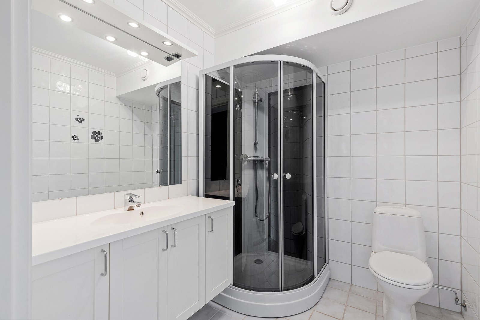 Flislagt baderom med lun gulvvarme og god oppbevaringsplass i baderomsinnredningen. Galleribilde