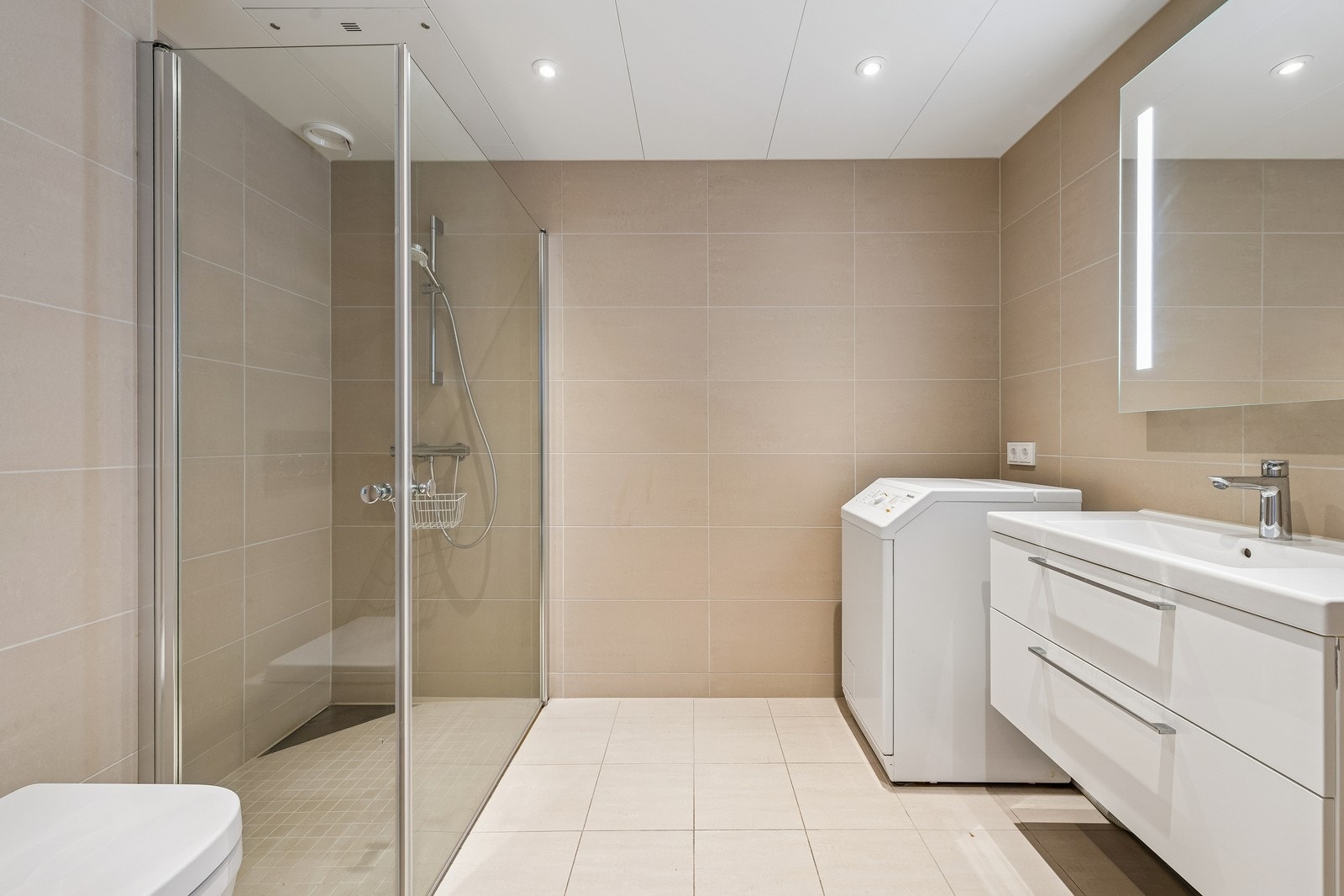 Flislagt bad med downlights og vaskemaskin Galleribilde