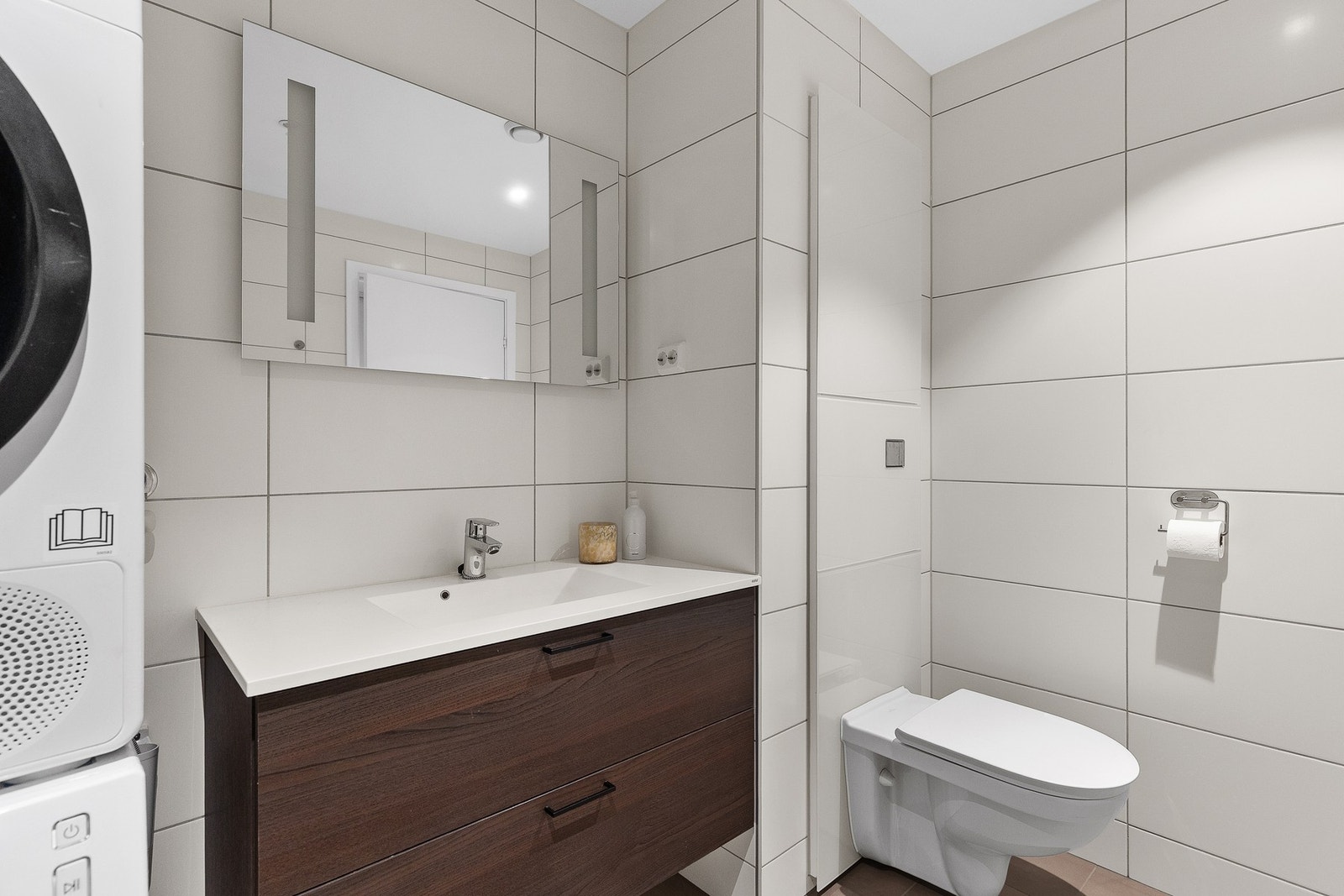 Pen baderomsinnredning med god lagringsplass og speil med integrert lys. Galleribilde