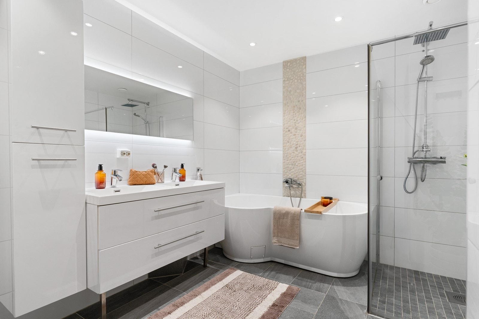 Delikat baderom fra 2017 innredet med badekar, toalett, rikelig med lagringsplass i garderobeinnredning . Lun behagelig varme i flislagt gulv. Galleribilde