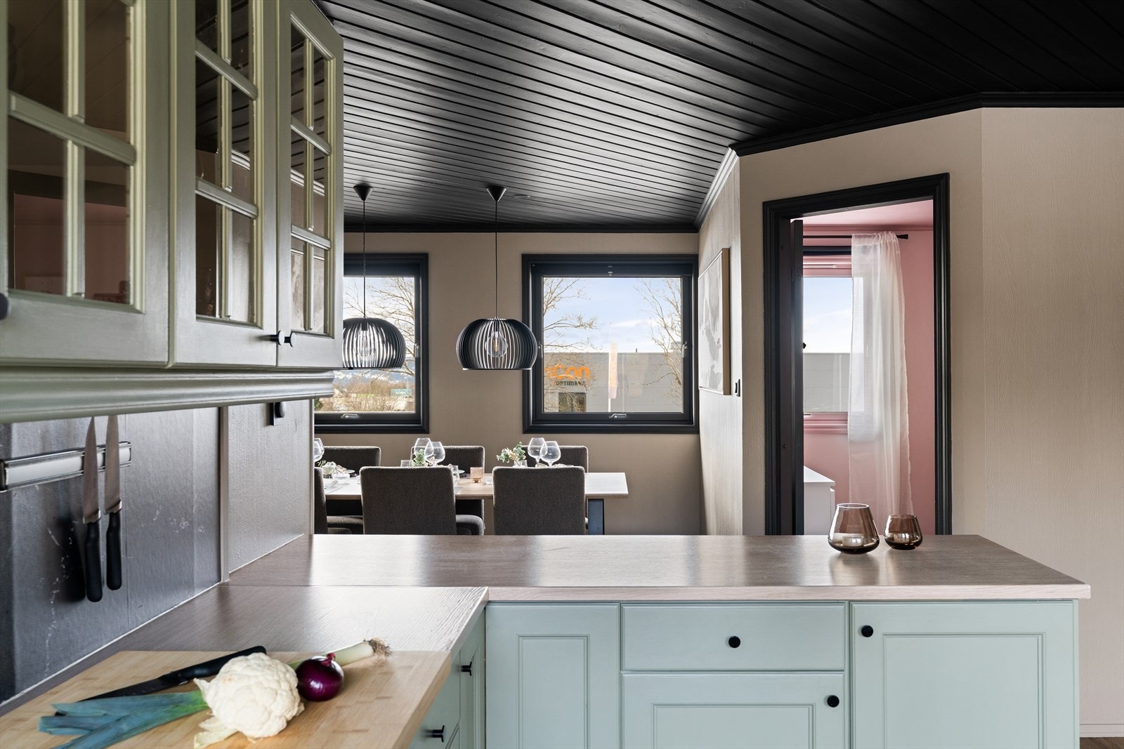 Kjøkkeninnredning med malte fronter og mye skap og benkeplass. Galleribilde