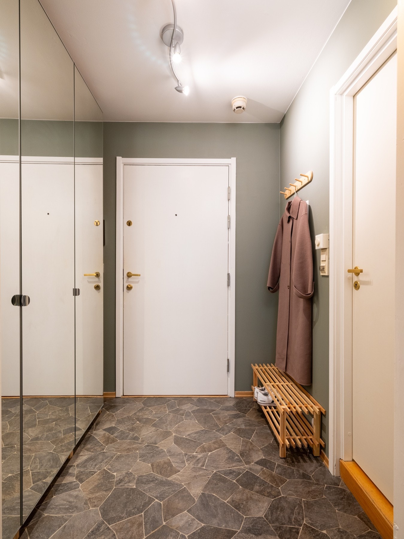 Inngangsparti med god plass til oppbevaring av sko og ytterklær i det store garderobeskapet med speilfronter. Galleribilde