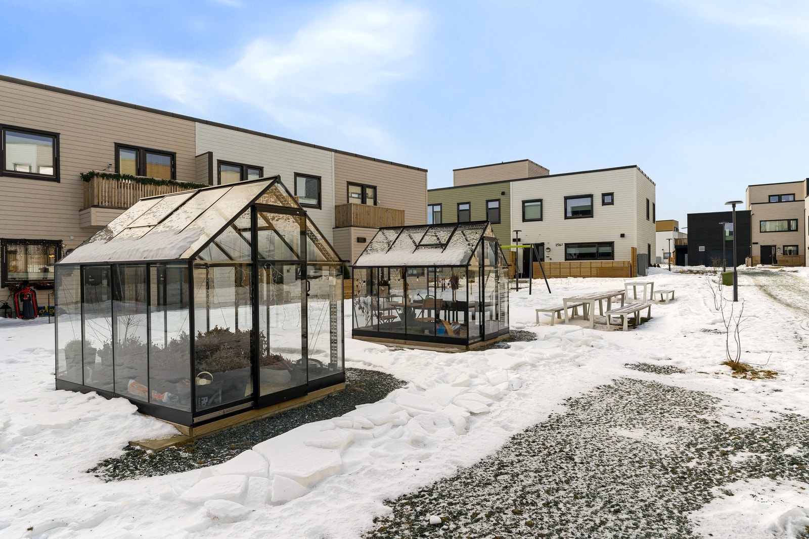 Hyggelig uteområde med drivhus som skaper en grønn og innbydende atmosfære. Galleribilde