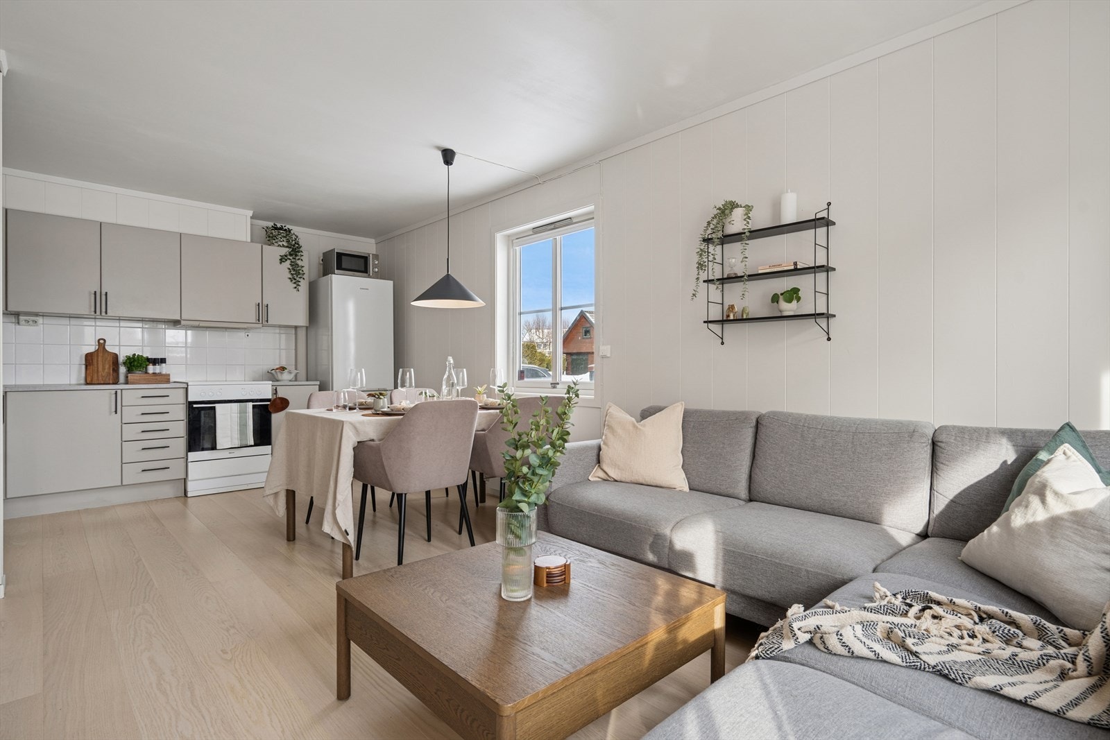 Stuen og kjøkkenet i åpen løsning med plass til spisebord og sofagruppe Galleribilde