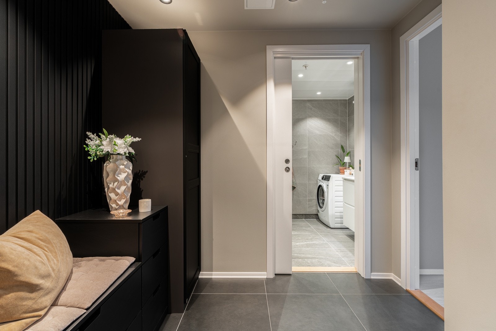 Velkommen inn! Stor, flislagt gang med gullvarme og lekre plassbygde oppbevaringsløsninger.