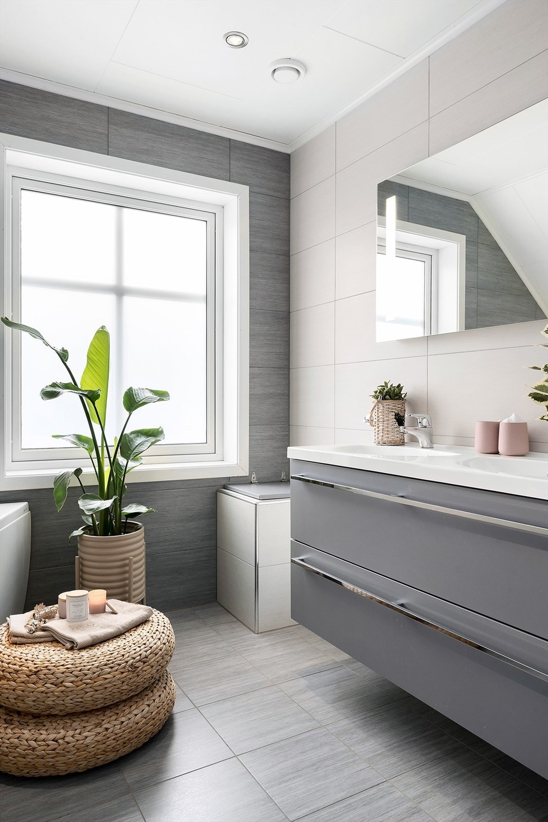 Badet er innredet med dobbel servant, skuffer, høyskap og speil med integrert lys. Galleribilde