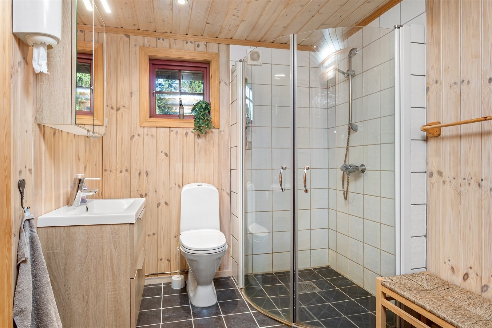Pent innredet bad med downlights i himling. Baderomsinnredningen har heldekkende nedfelt servant og rom for oppbevaring i skuffeseksjoner, speilskap med belysning, toalett og dusjhjørne med innfellbare dusjvegger. Galleribilde