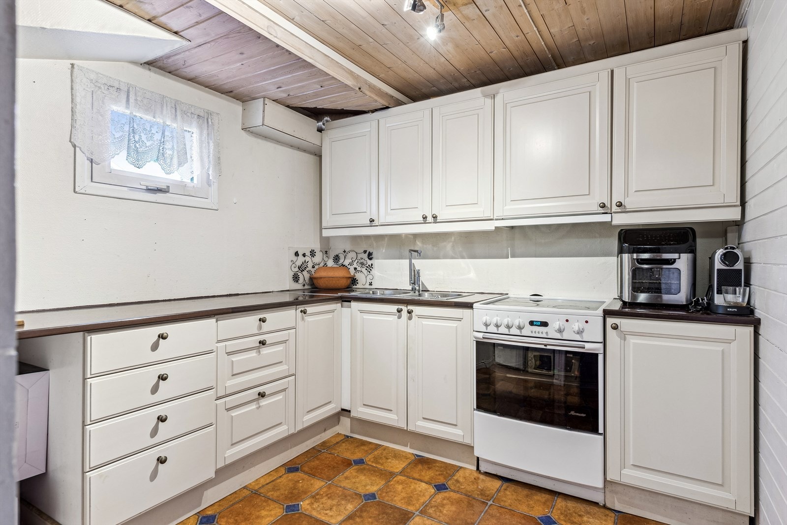 Kjellerkjøkken med laminerte benkeplater og innredning med profilerte fronter. Galleribilde