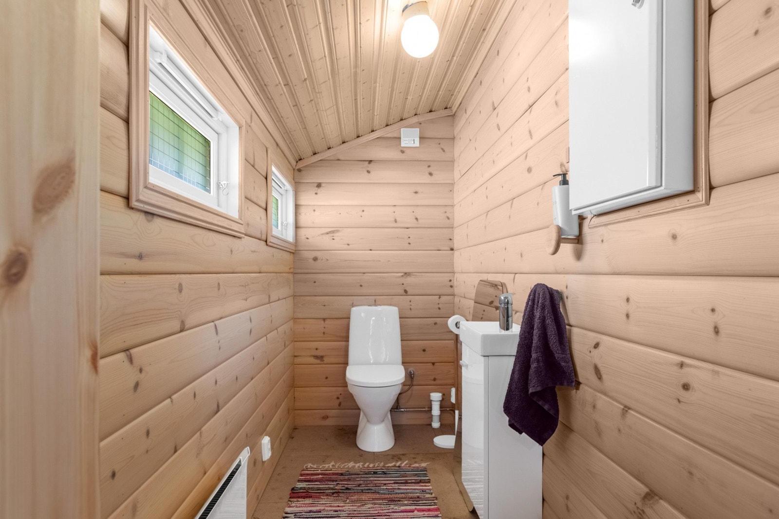 Praktisk toalettrom med vannklosett og vask. Nyetablert entré og toalettrom har flislagt gulv. Galleribilde