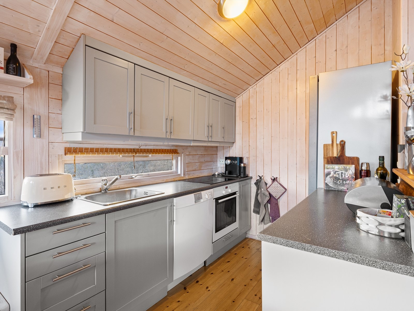 Grått kjøkken med god lagringsplass i skuffer og skap. Galleribilde