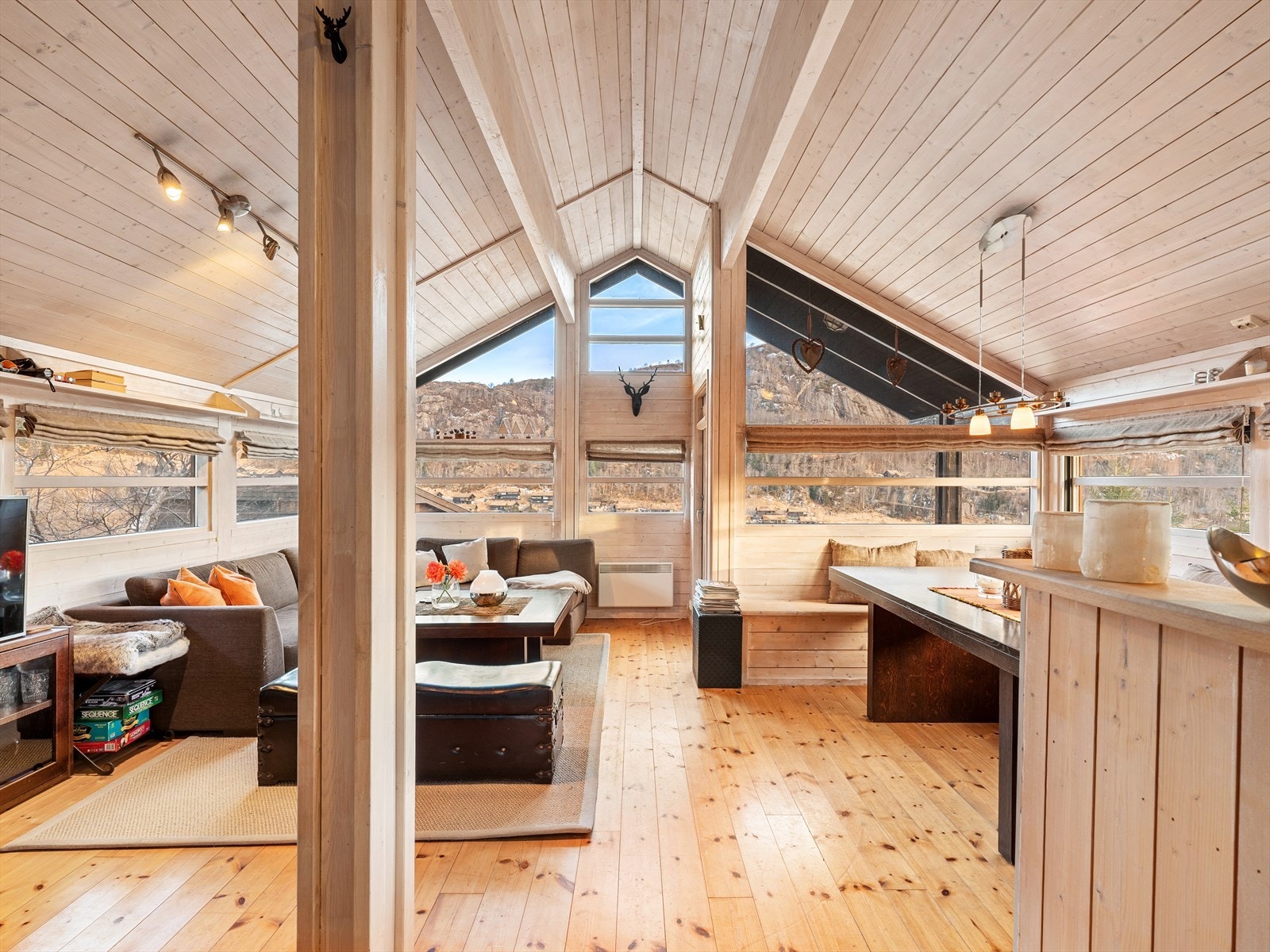 Stue og kjøkken i åpen løsning. Furugulv og lysnet panel på vegger. Galleribilde