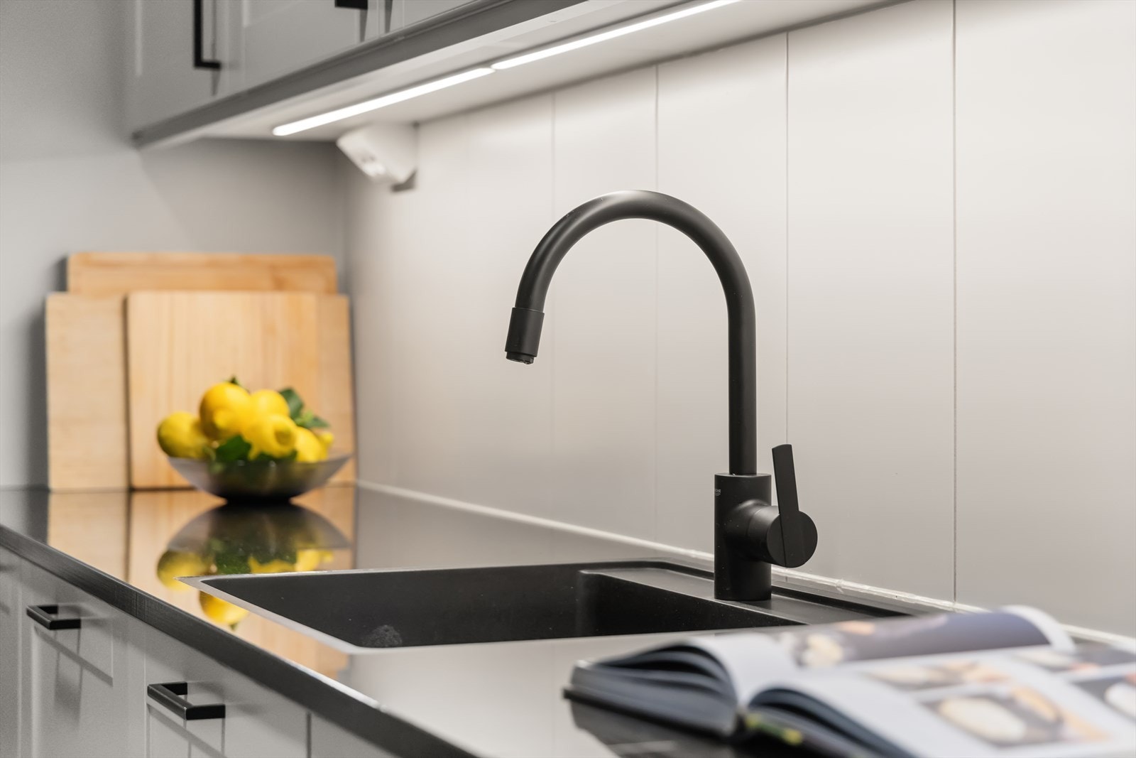 Kjøkkenet har integrerte hvitevarer som kjøleskap, oppvaskmaskin, komfyr og platetopp Galleribilde