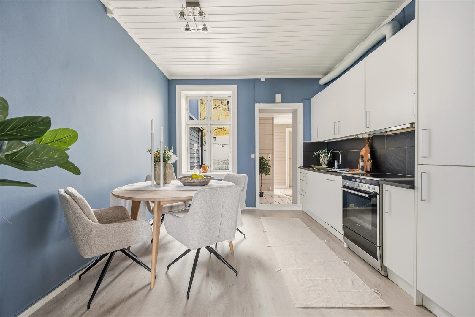 Pent kjøkken med glatte fronter, flislagt over kjøkkenbenk og benkeplate i laminat fra 2026 Galleribilde