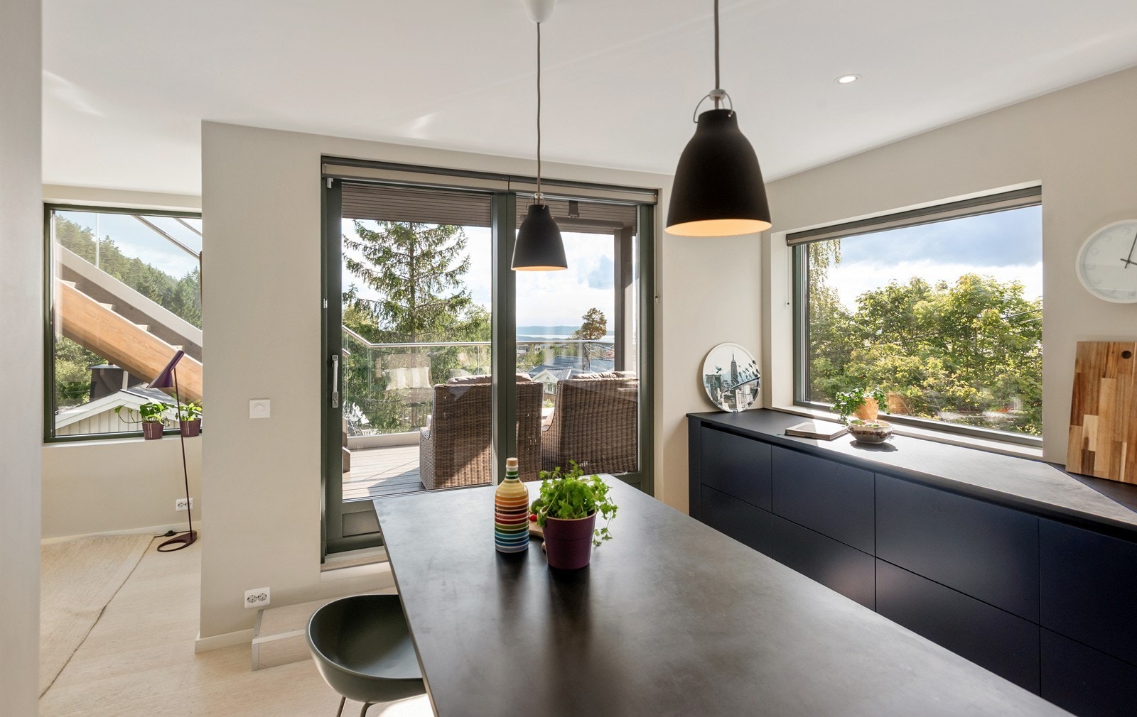Lysvennlig kjøkken med direkte utgang til solrik utsiktsbalkong og trapp videre opp til takterrassen Galleribilde