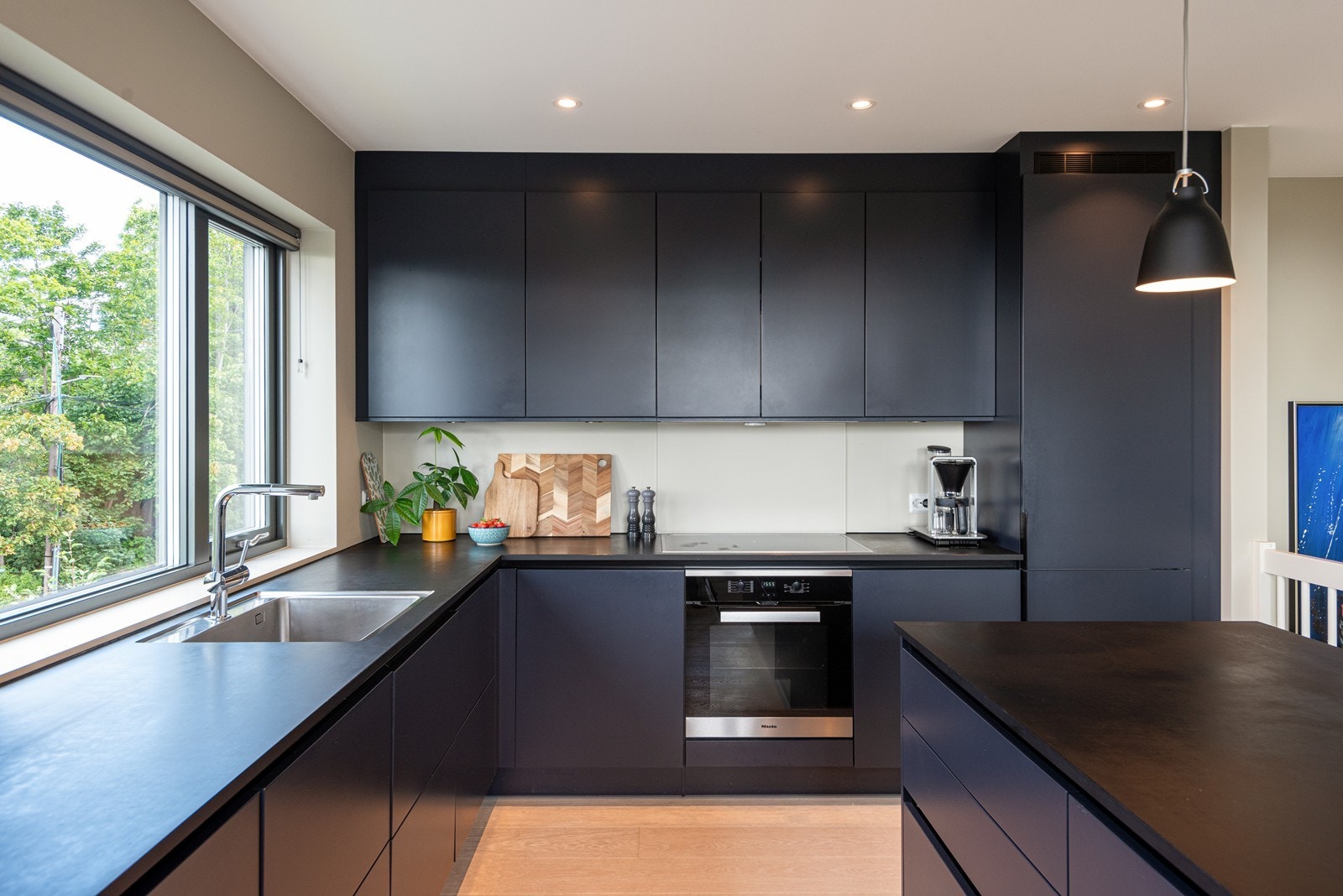 Moderne kjøkkeninnredning fra 2019 med praktisk kjøkkenøy og masse lys Galleribilde