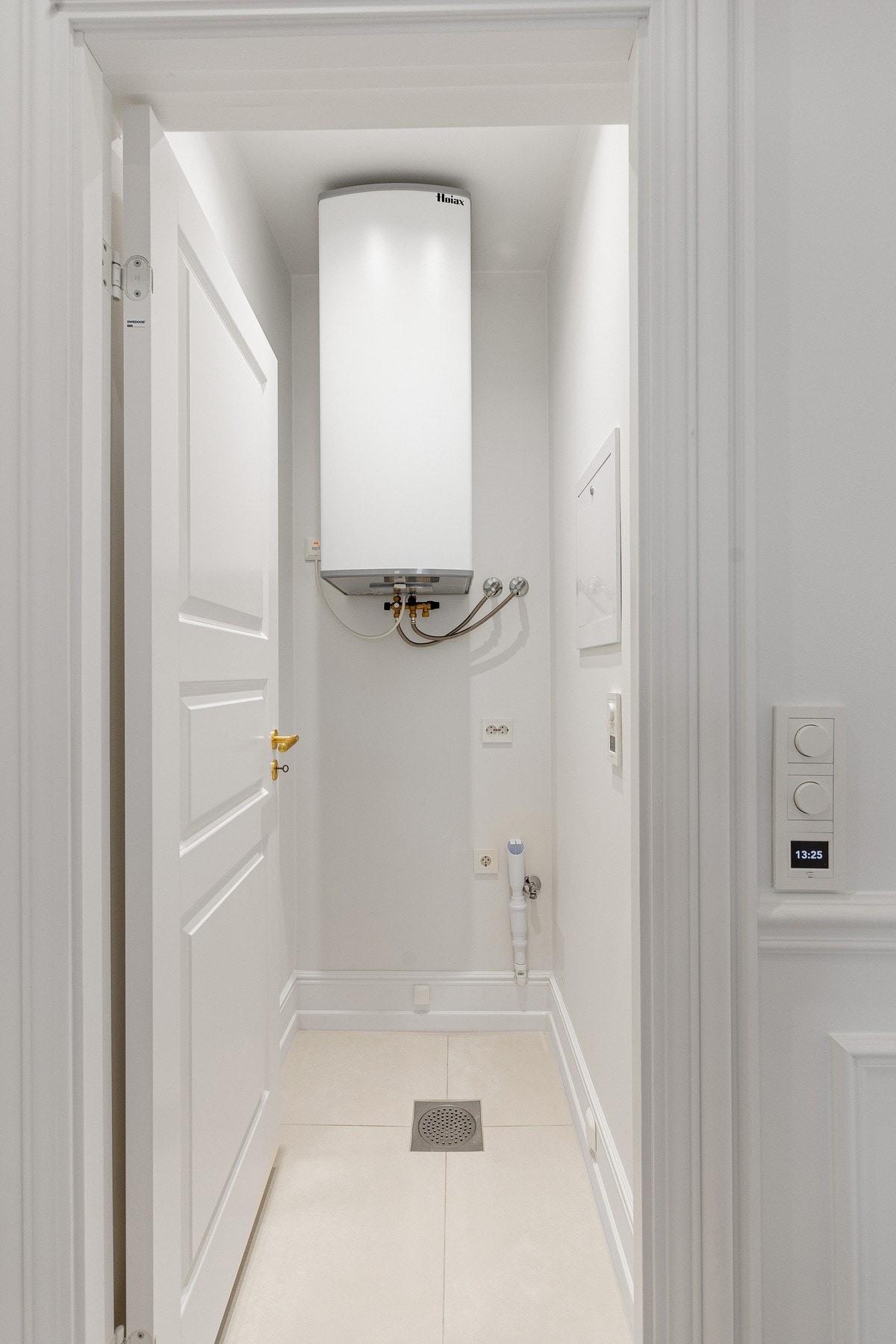 Superpraktisk vaskerom med sluk, varmtvannsbereder og opplegg for vaskemaskin. Galleribilde