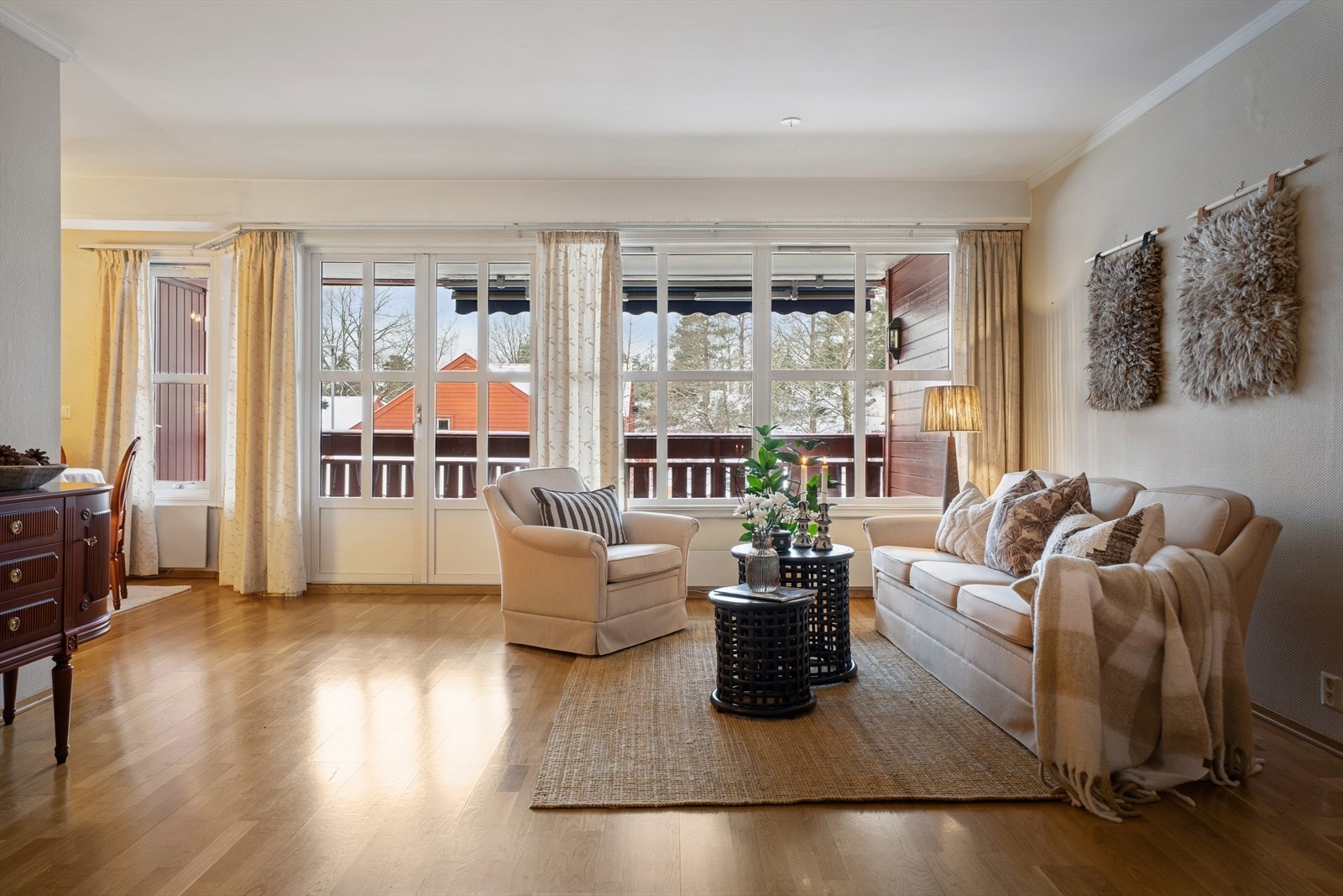 Store vinduer og en terrassedør slipper inn rikelig med dagslys og skaper en lys og behagelig atmosfære Galleribilde