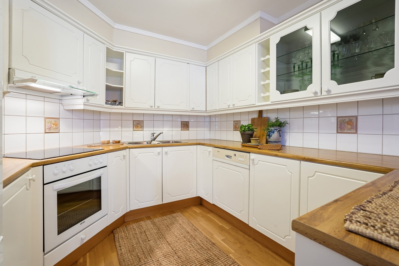 Vinkelformet kjøkkeninnredning med god skapplass i både skuffer og skap Galleribilde