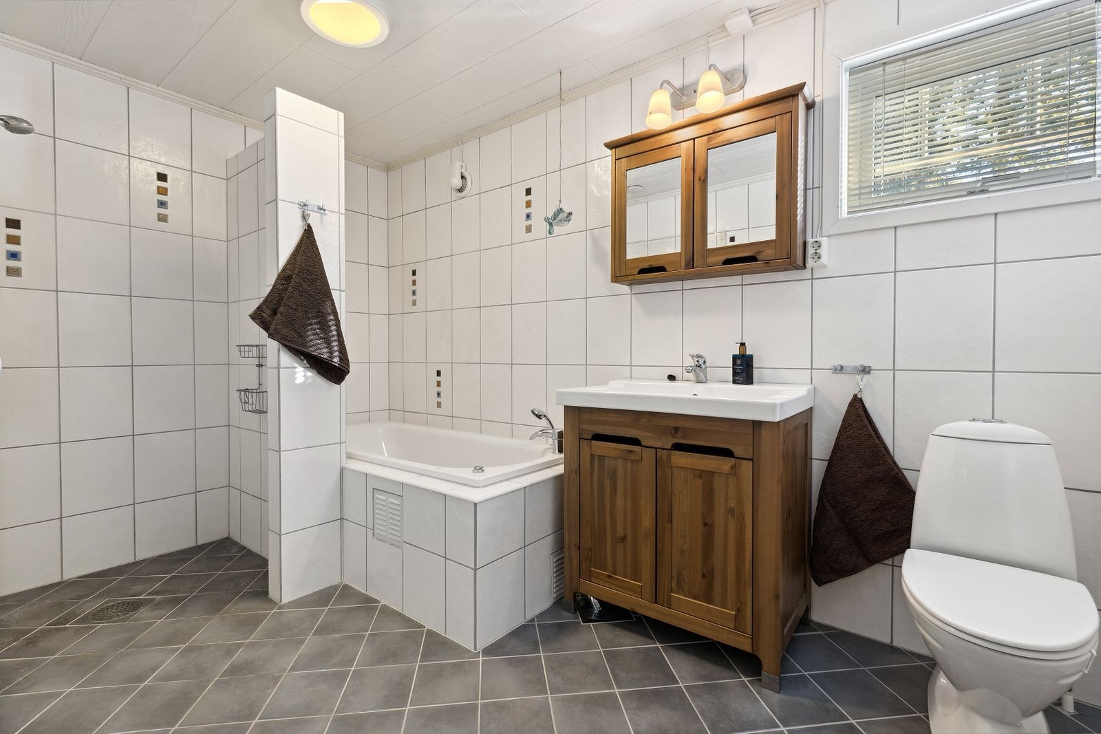 Romslig bad med badekar og tidløse fliser. Galleribilde