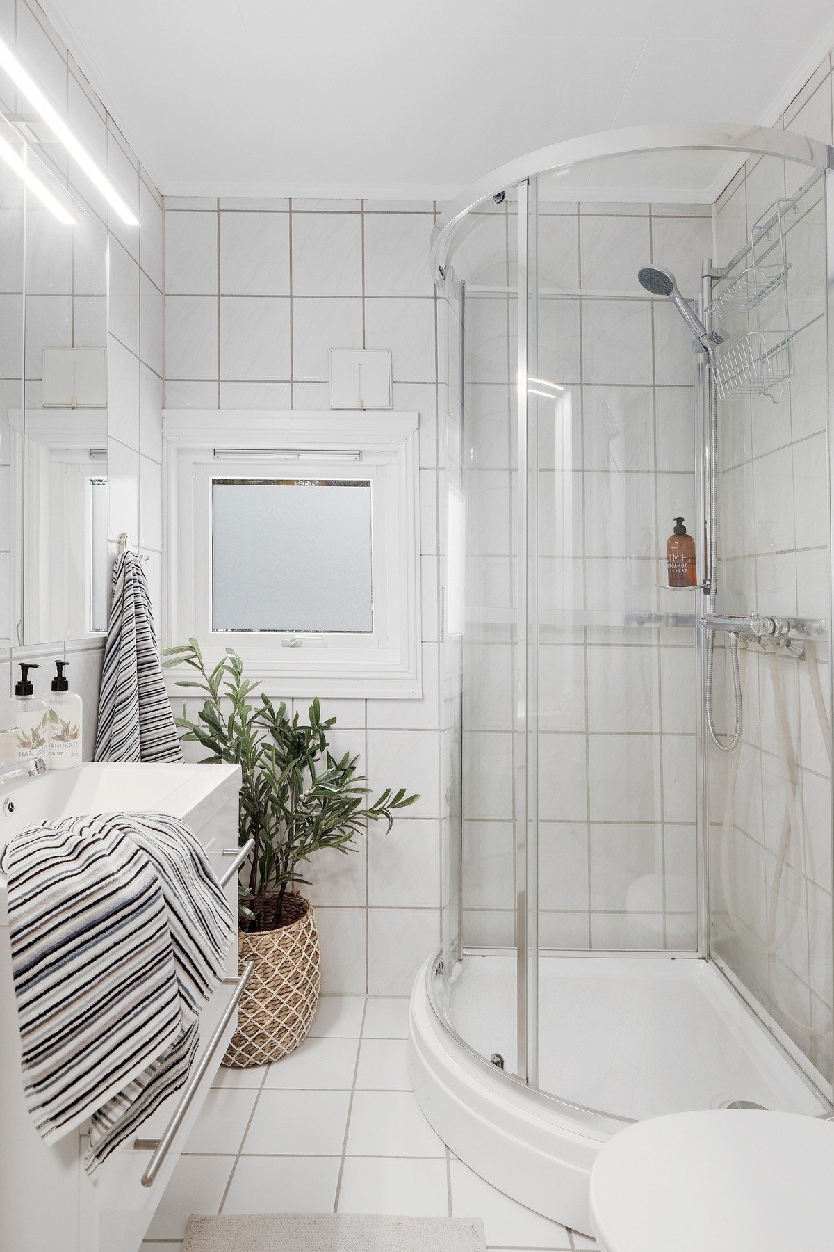 Leiligheten har et stort bad med flislagte vegger og gulv med varme Galleribilde