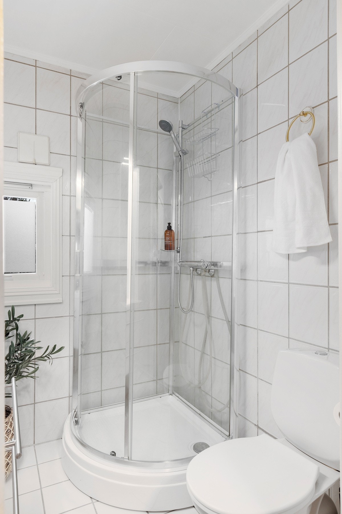 Badet inneholder: Vegghengt servantinnredning, dusjkabinett med dusjarmatur tilkoblet hånddusj og gulvstående toalett. Galleribilde