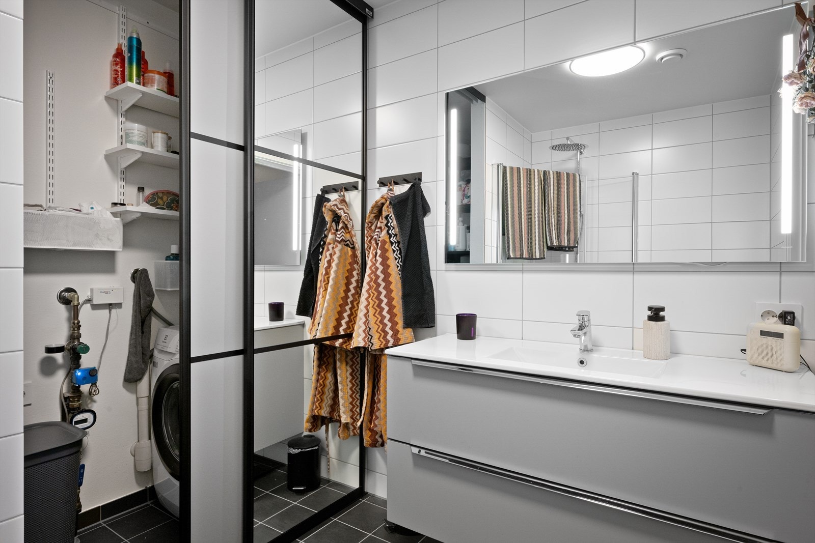 Bad i 1. etasje, smart løsning med skyvedører montert for å skjule vaskemaskin, varmtvangsbereder og vaskemidler Galleribilde