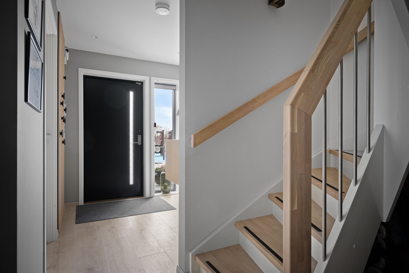 Lys og innbydende entré med moderne detaljer og praktisk trappeadkomst, perfekt for et stilrent og funksjonelt hjem. Galleribilde