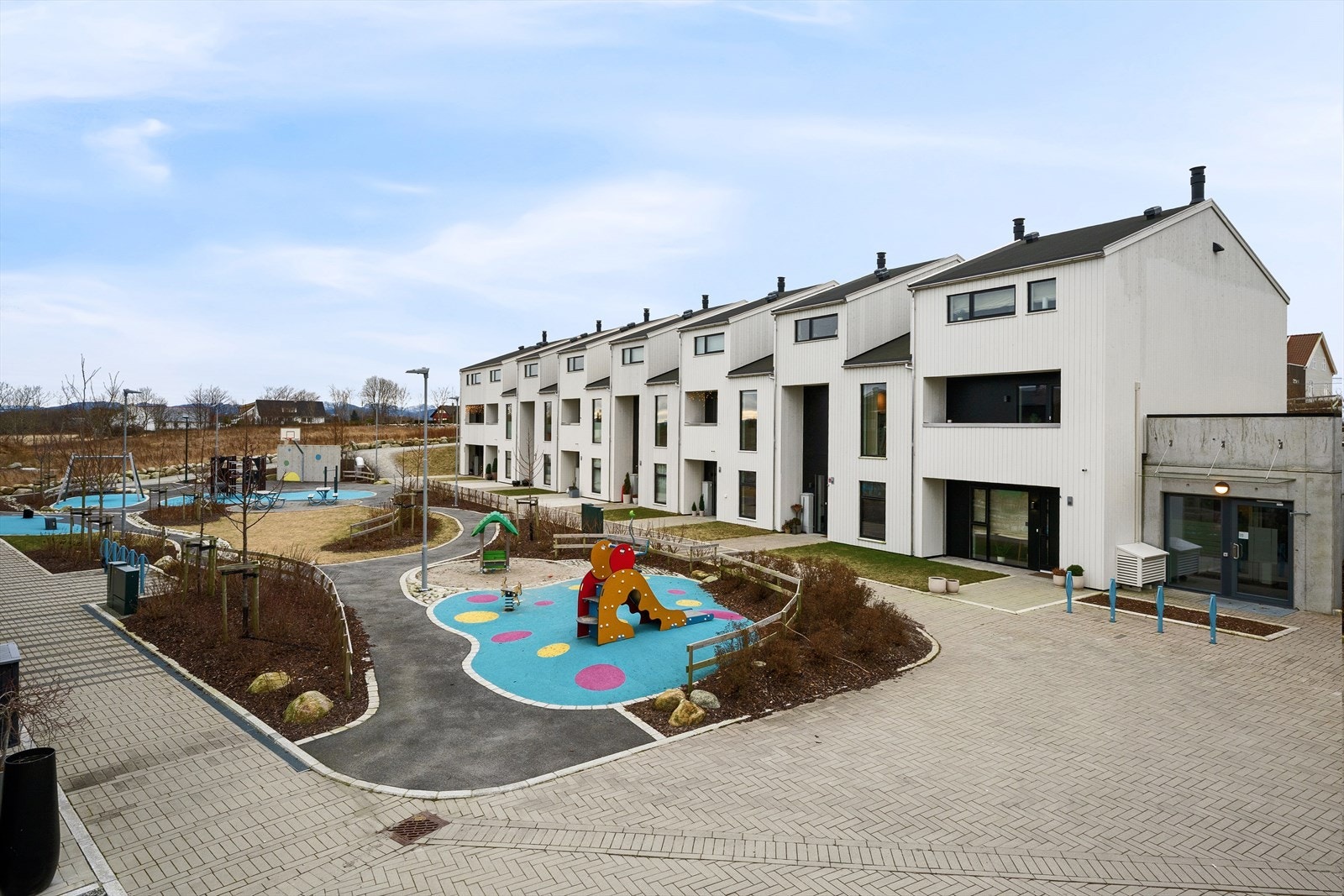 Kjekke utearealer med opparbeidet lekeplass og pent beplantet Galleribilde