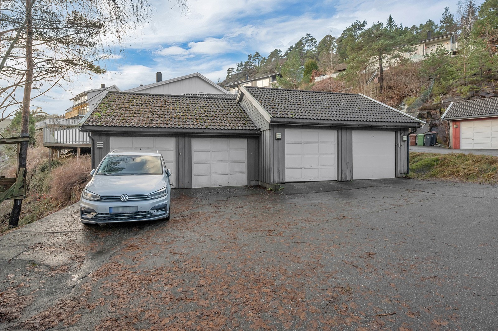 Det følger med garasje i rekke (nr. 2 fra venstre) med fjernkontroll og portåpner, ca. 75 meter fra tomannsboligen. Galleribilde