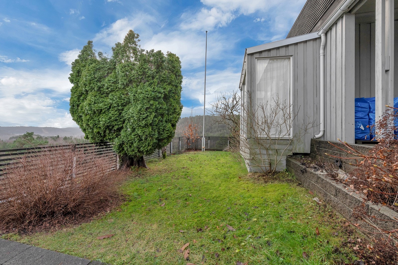 Fint opparbeidet plen, og flaggstang på tomten. Galleribilde