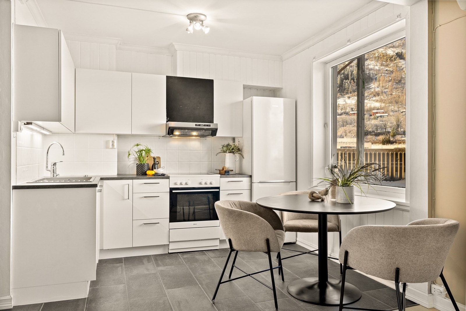 Lyst og praktisk kjøkken med plass til å spisebord. Galleribilde