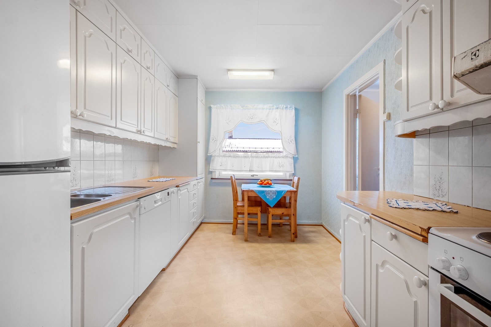 Kjøkkenet ligger i eget rom, og har innredning med profilerte fronter. Benkeplate i laminat. Galleribilde