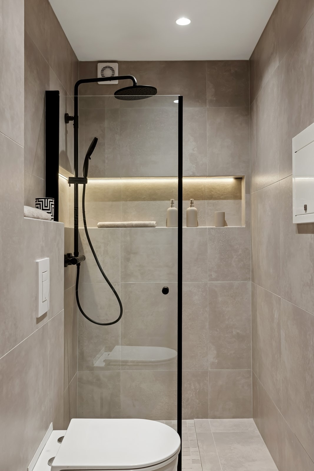 Badet har vegghengt toalett og et dusjhjørne med skillevegg i herdet glass. Galleribilde