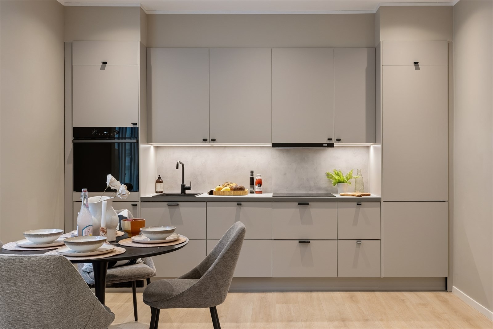 Smakfullt og moderne kjøkken fra 2026 med laminerte skrog, slette fronter og benkeplate i laminat, utstyrt med kjøkkenkran og nedfelt oppvaskkum. Galleribilde