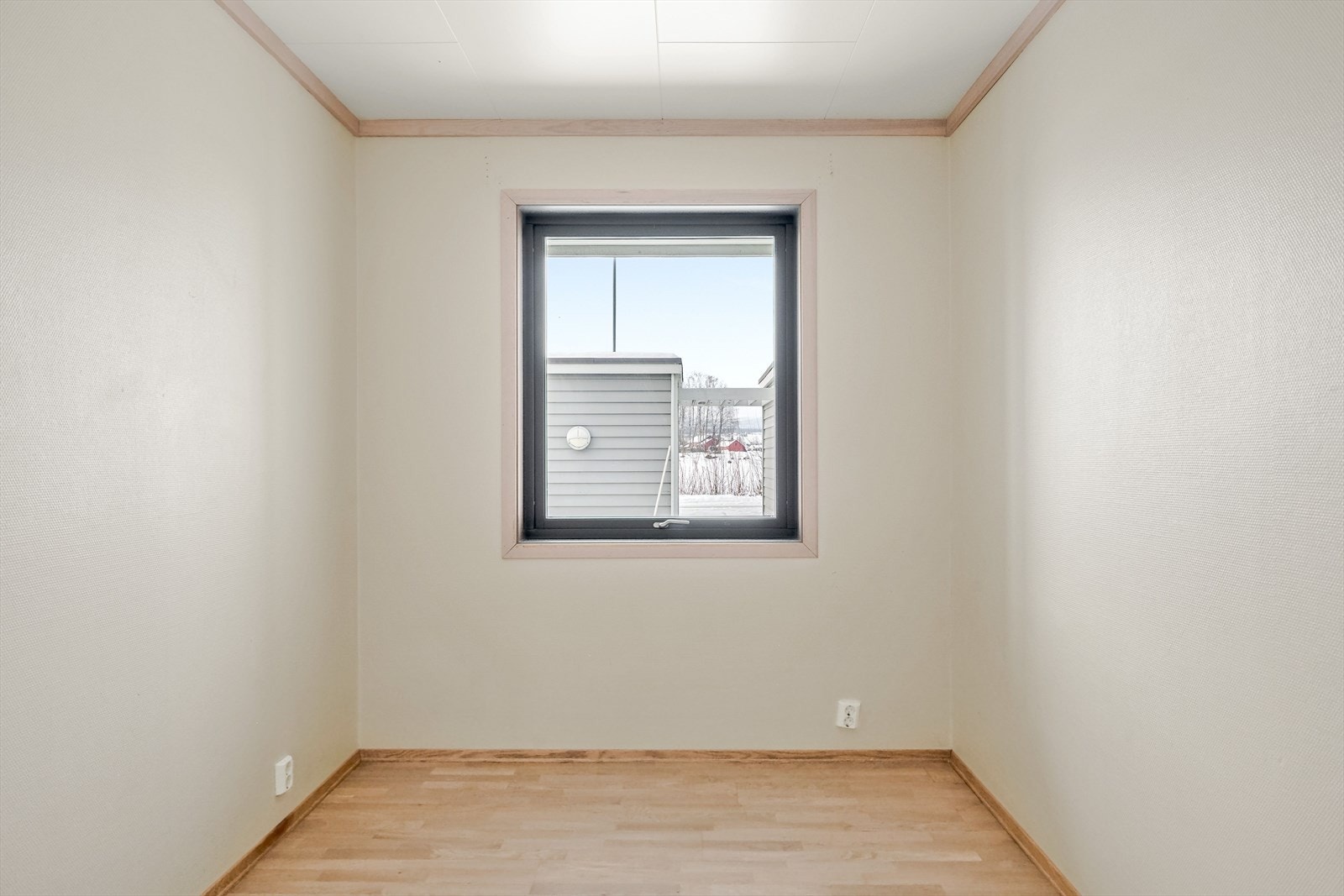 Det ene soverommet 1. etasje har vindu på kortveggen, lyse vegger og parkettgulv. Galleribilde